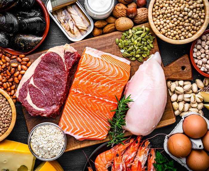 Các loại thực phẩm chứa protein bao gồm thịt bò, cá hồi, ức gà, trứng, tôm, hạt và các loại đậu.